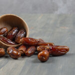 Sweet dates out of wooden bowl on marble background. High quality photo